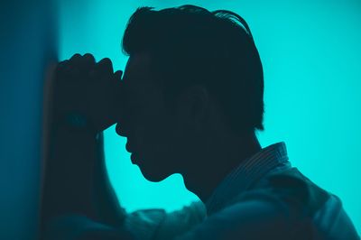 a Man leaning against a wall.
